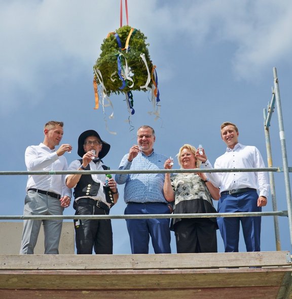 Vertreter der WGH und Zimmerleute mit Richtkranz