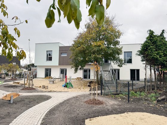Ansicht des Kitagebäudes mit Spielplatz