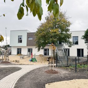 Ansicht des Kitagebäudes mit Spielplatz