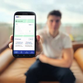 Junger Manan zeigt sein Smartphone mit der WGH-Mieterapp