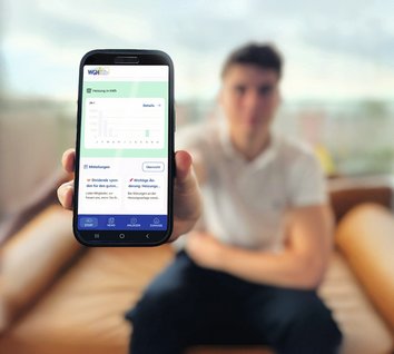 Junger Manan zeigt sein Smartphone mit der WGH-Mieterapp