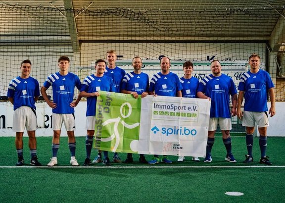 Fussballspieler im Trikot mit Banner in der Hand